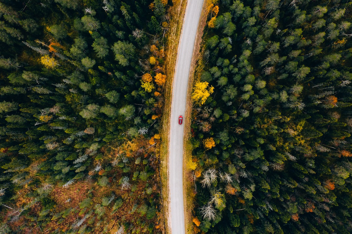 Aerial View Of Rural Road In Yellow And Orange Autumn Forest In Rural Finland.